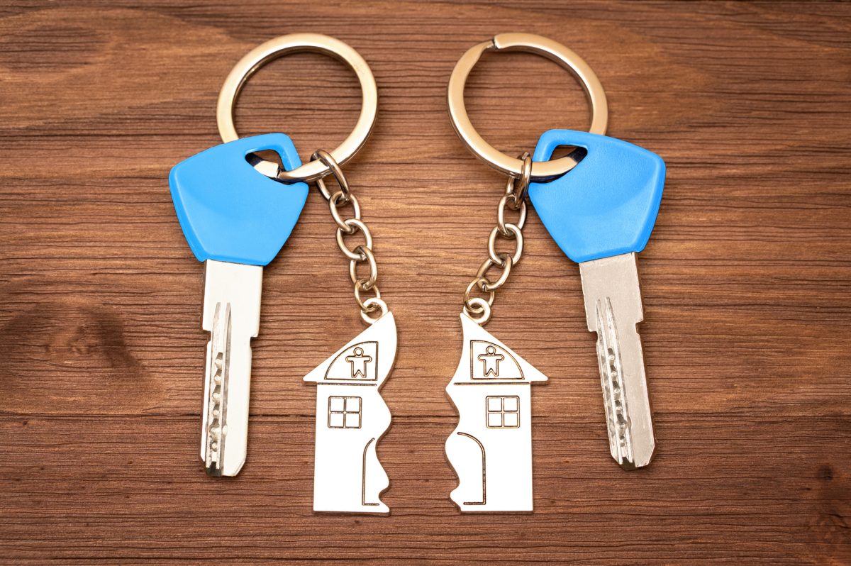 Two house-shaped keychains with keys representing siblings disputing inherited property in Florida